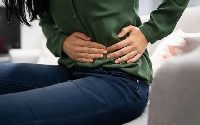 Woman holding lower abdomen showing pain and discomfort that may indicate a hernia
