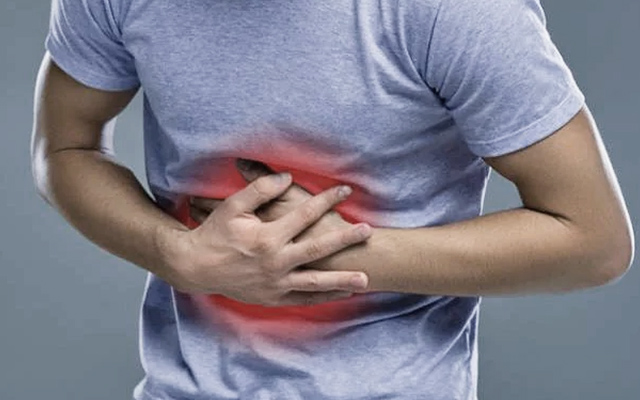 Man holding his side in pain, possibly indicating hernia discomfort or abdominal pain.